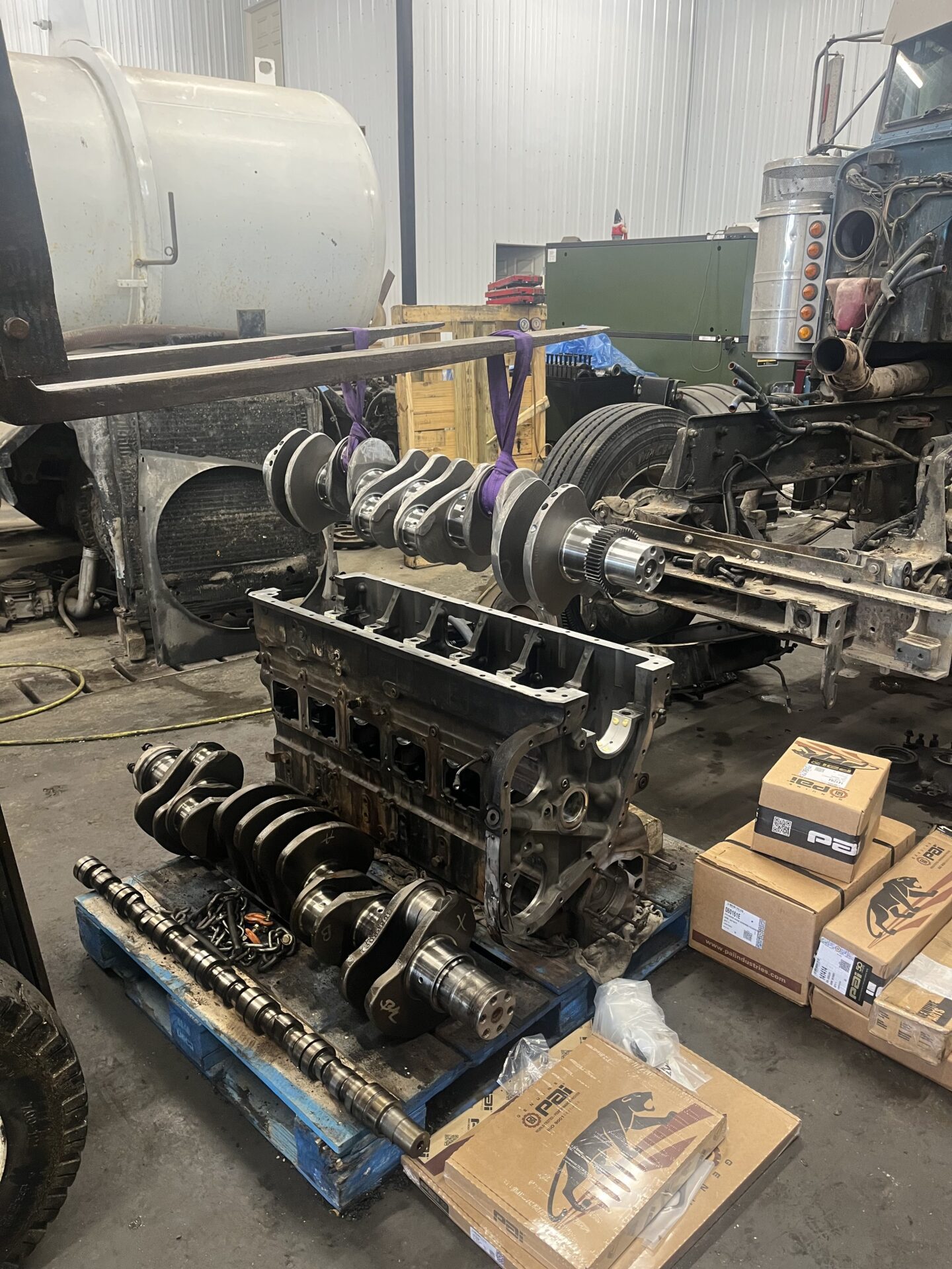 A truck engine displayed on a table within a spacious warehouse environment.